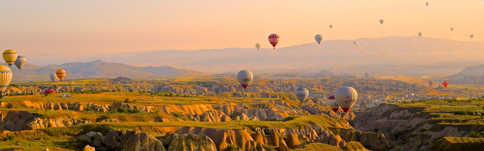 Hot air balloons flying over a mountain landscape